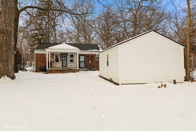 exterior space with a porch, brick siding, and a chimney