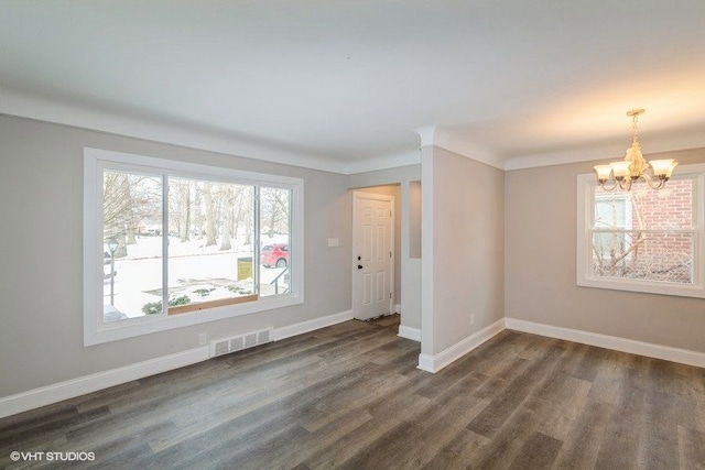 unfurnished room featuring a chandelier, dark wood-type flooring, visible vents, and baseboards