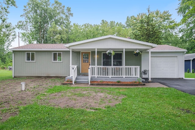 ranch-style home with covered porch, driveway, a front lawn, and a garage