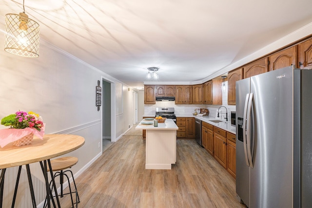 kitchen featuring a center island, stainless steel appliances, light countertops, backsplash, and a sink