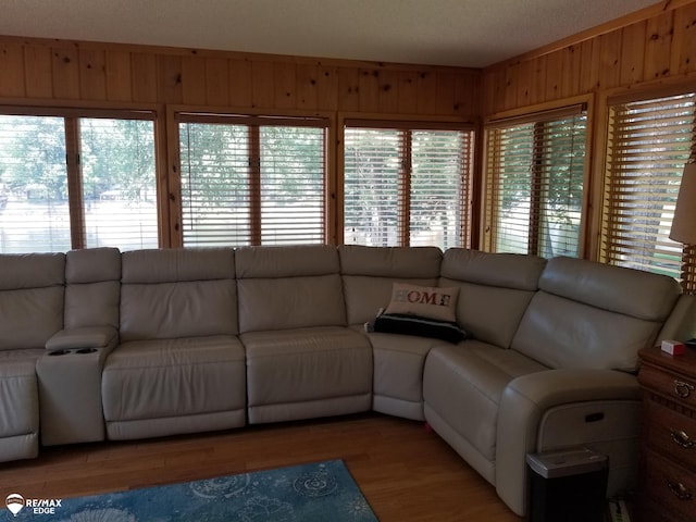 living room with wood finished floors and wooden walls