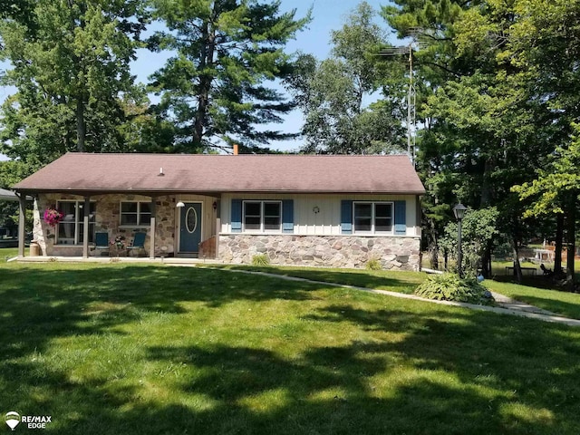 single story home with a front lawn, stone siding, and covered porch
