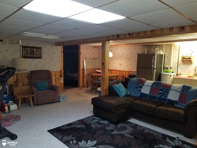 living room with a drop ceiling, wainscoting, carpet flooring, and wallpapered walls