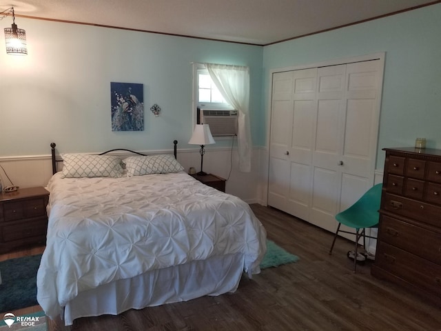 bedroom with cooling unit, wood finished floors, a closet, and ornamental molding