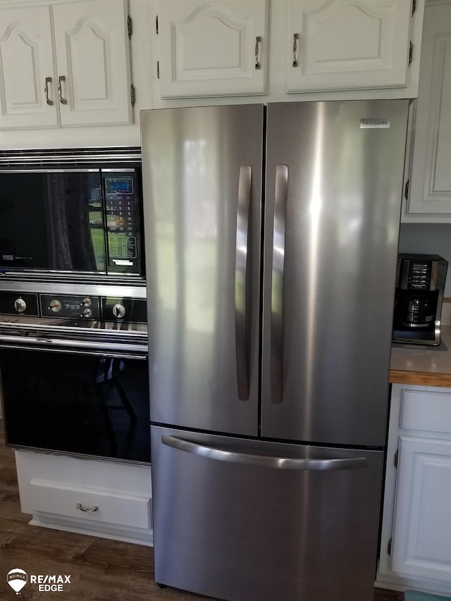 kitchen featuring black appliances, white cabinetry, and wood finished floors
