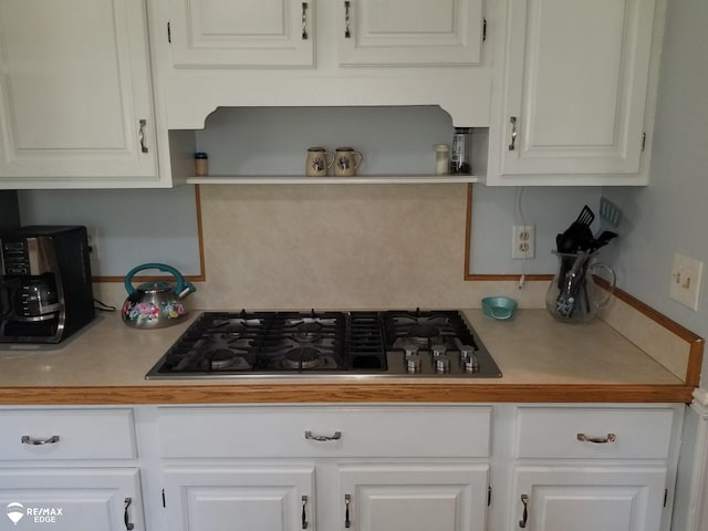 kitchen with white cabinets, open shelves, stainless steel gas stovetop, and light countertops