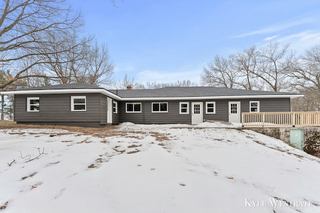 snow covered rear of property featuring a wooden deck