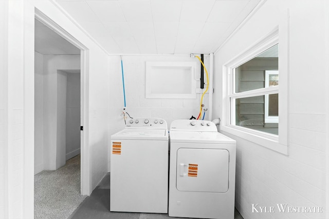 laundry room featuring concrete block wall, laundry area, and independent washer and dryer