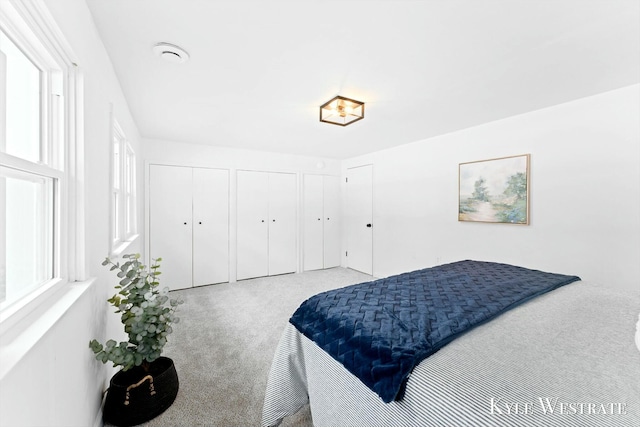 bedroom featuring multiple closets and carpet flooring