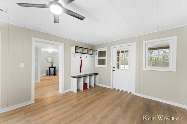 interior space with light wood finished floors, a ceiling fan, and baseboards