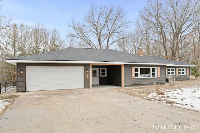 ranch-style house featuring concrete driveway, roof with shingles, a chimney, and an attached garage