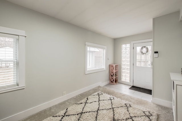 entrance foyer with a wealth of natural light, baseboards, and light tile patterned floors