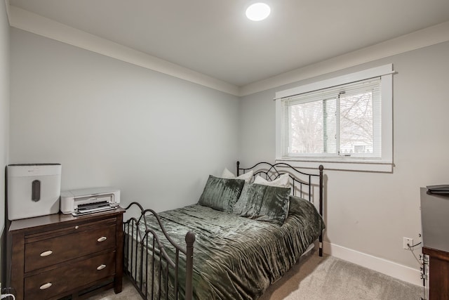 bedroom featuring light carpet and baseboards