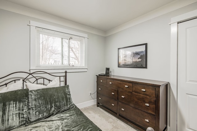 bedroom with light carpet and baseboards