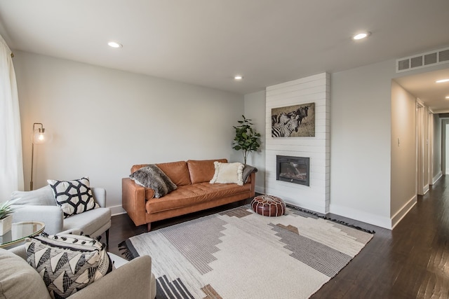 living area featuring recessed lighting, a large fireplace, visible vents, baseboards, and dark wood finished floors