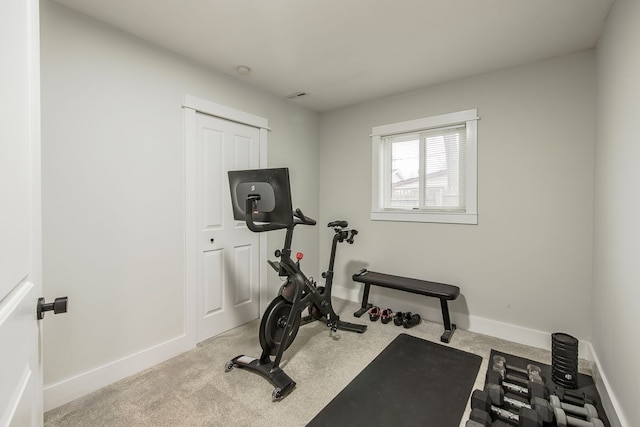 workout room featuring carpet and baseboards