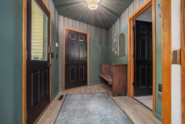 foyer entrance with visible vents, baseboards, and wood finished floors