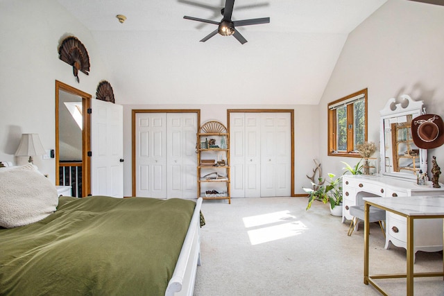 bedroom featuring lofted ceiling, carpet, a ceiling fan, and two closets