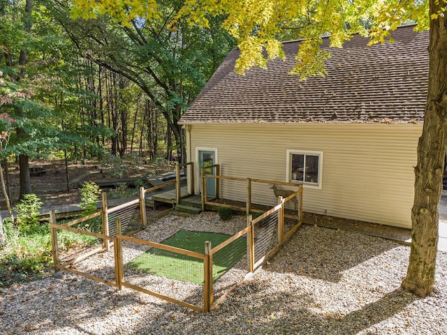 view of property exterior featuring fence and a wooden deck