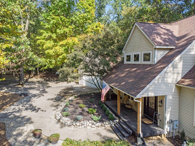 exterior space with a shingled roof and an outdoor structure