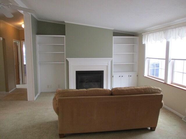 living area featuring carpet, ornamental molding, a glass covered fireplace, vaulted ceiling, and baseboards