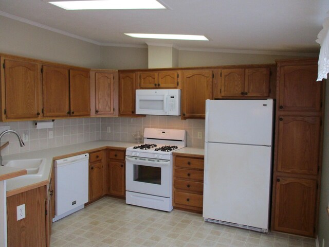 kitchen with white appliances, a sink, light countertops, brown cabinets, and decorative backsplash