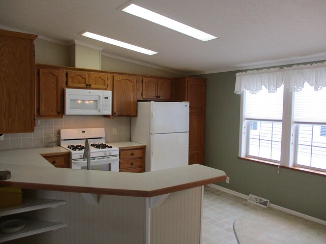 kitchen with ornamental molding, lofted ceiling, white appliances, and light countertops