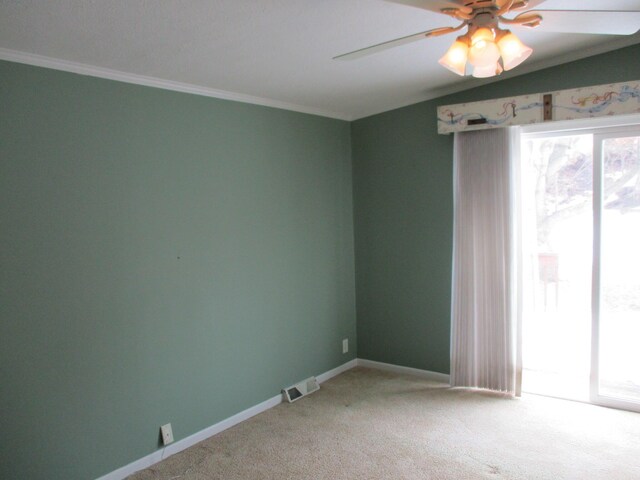 unfurnished room with visible vents, ornamental molding, light carpet, ceiling fan, and baseboards