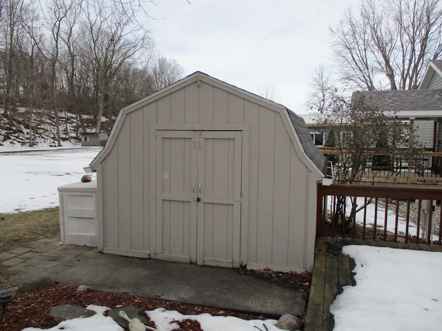 snow covered structure with a shed and an outdoor structure