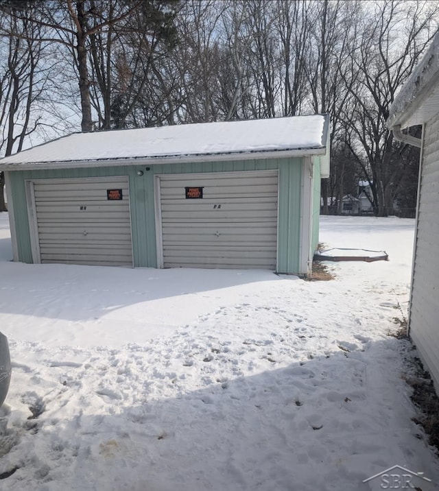 snow covered garage featuring a garage