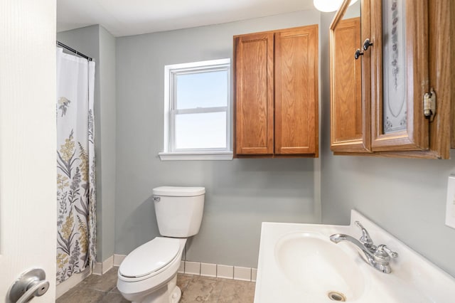 bathroom with a shower with shower curtain, toilet, vanity, baseboards, and tile patterned floors