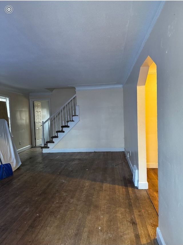 interior space with hardwood / wood-style flooring, baseboards, stairway, and crown molding