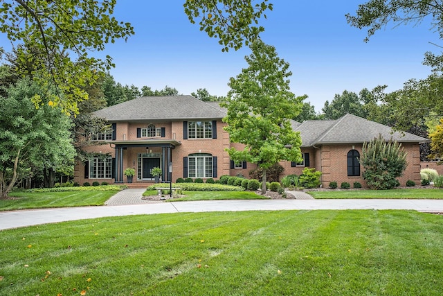 georgian-style home with brick siding and a front yard