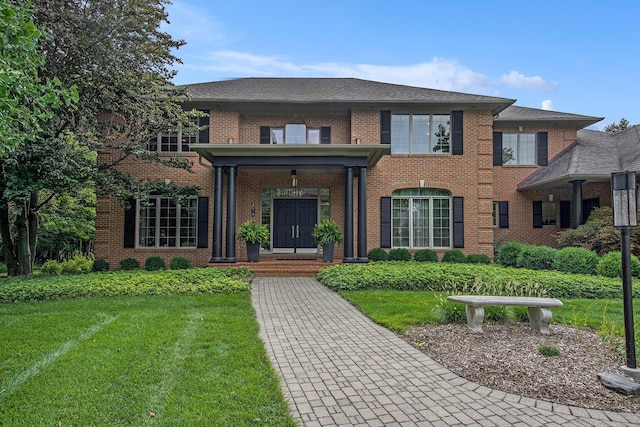 view of front of home with brick siding and a front lawn