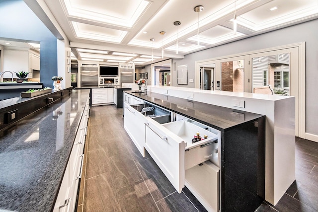 kitchen with wood finish floors, a spacious island, white cabinets, a sink, and coffered ceiling