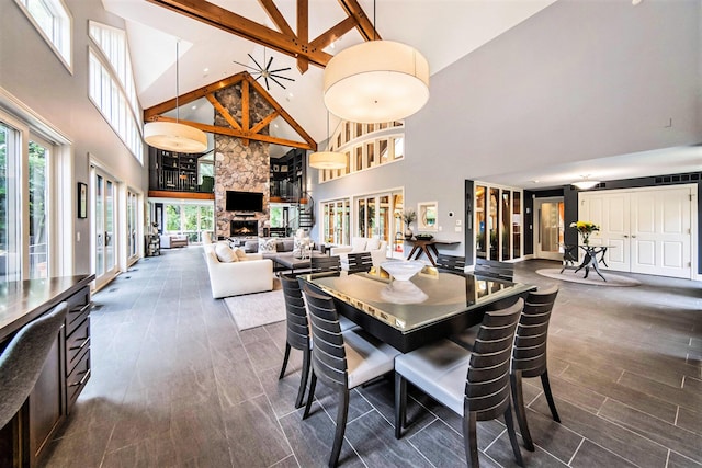 dining space featuring dark wood-style floors, a high ceiling, and a fireplace