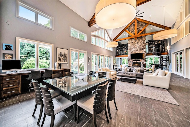 dining space with high vaulted ceiling, a fireplace, beamed ceiling, and stairs