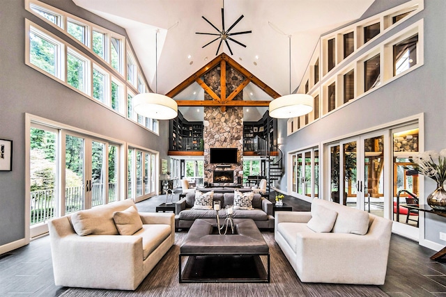 living area featuring a healthy amount of sunlight, a fireplace, baseboards, and french doors