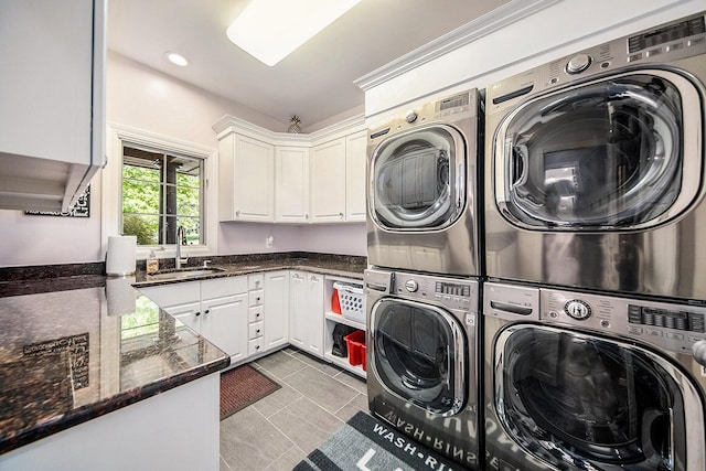 washroom featuring tile patterned flooring, stacked washer / dryer, a sink, independent washer and dryer, and cabinet space