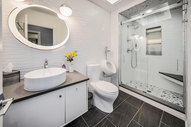 full bath featuring tile walls, a shower stall, toilet, and vanity