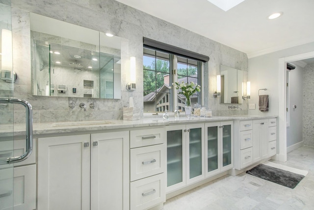 full bath featuring double vanity, a stall shower, marble finish floor, and a sink