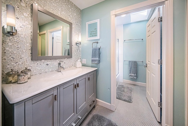 bathroom with  shower combination, vanity, baseboards, and tasteful backsplash