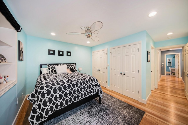 bedroom with multiple closets, recessed lighting, ceiling fan, light wood-type flooring, and baseboards