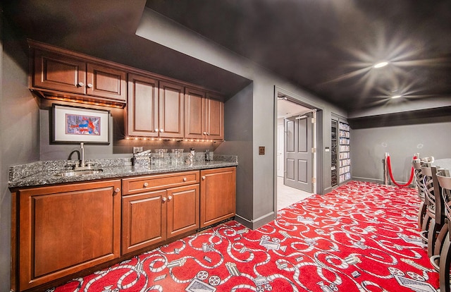 bar with a sink and baseboards