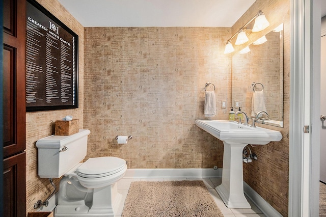 bathroom with toilet, tile patterned flooring, and baseboards