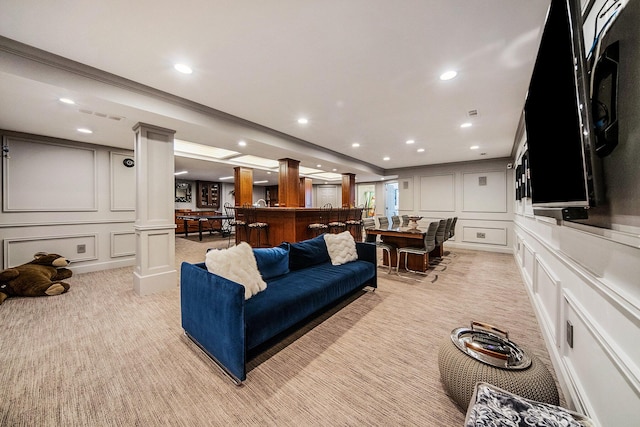 living room with recessed lighting, light colored carpet, a decorative wall, bar area, and decorative columns