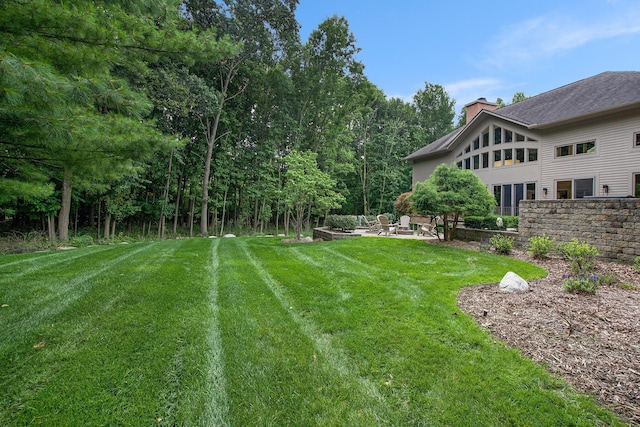 view of yard featuring a patio and an outdoor fire pit