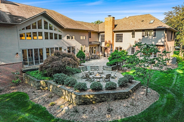 rear view of house with a patio, an outdoor fire pit, and a chimney