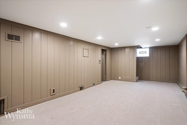 basement featuring light colored carpet, recessed lighting, and visible vents