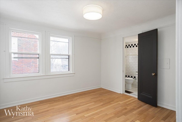 unfurnished room with light wood-style floors and baseboards